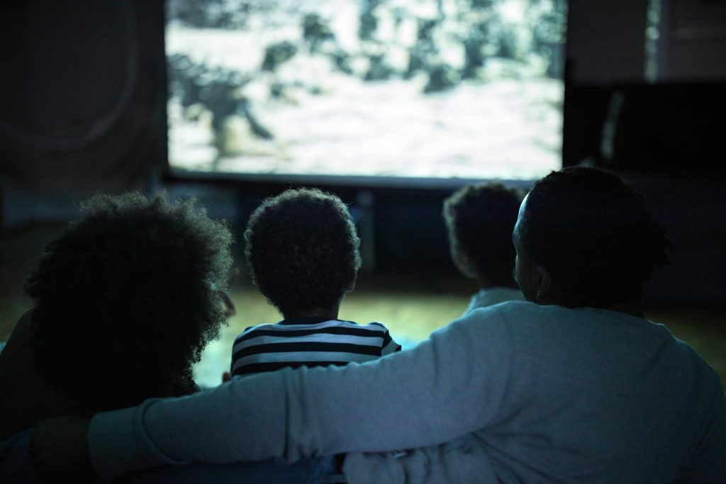 Família assistindo a filme sobre como falar sobre a morte com crianças